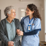 Young,Caregiver,Helping,Senior,Woman,Walking.,Nurse,Assisting,Her,Old